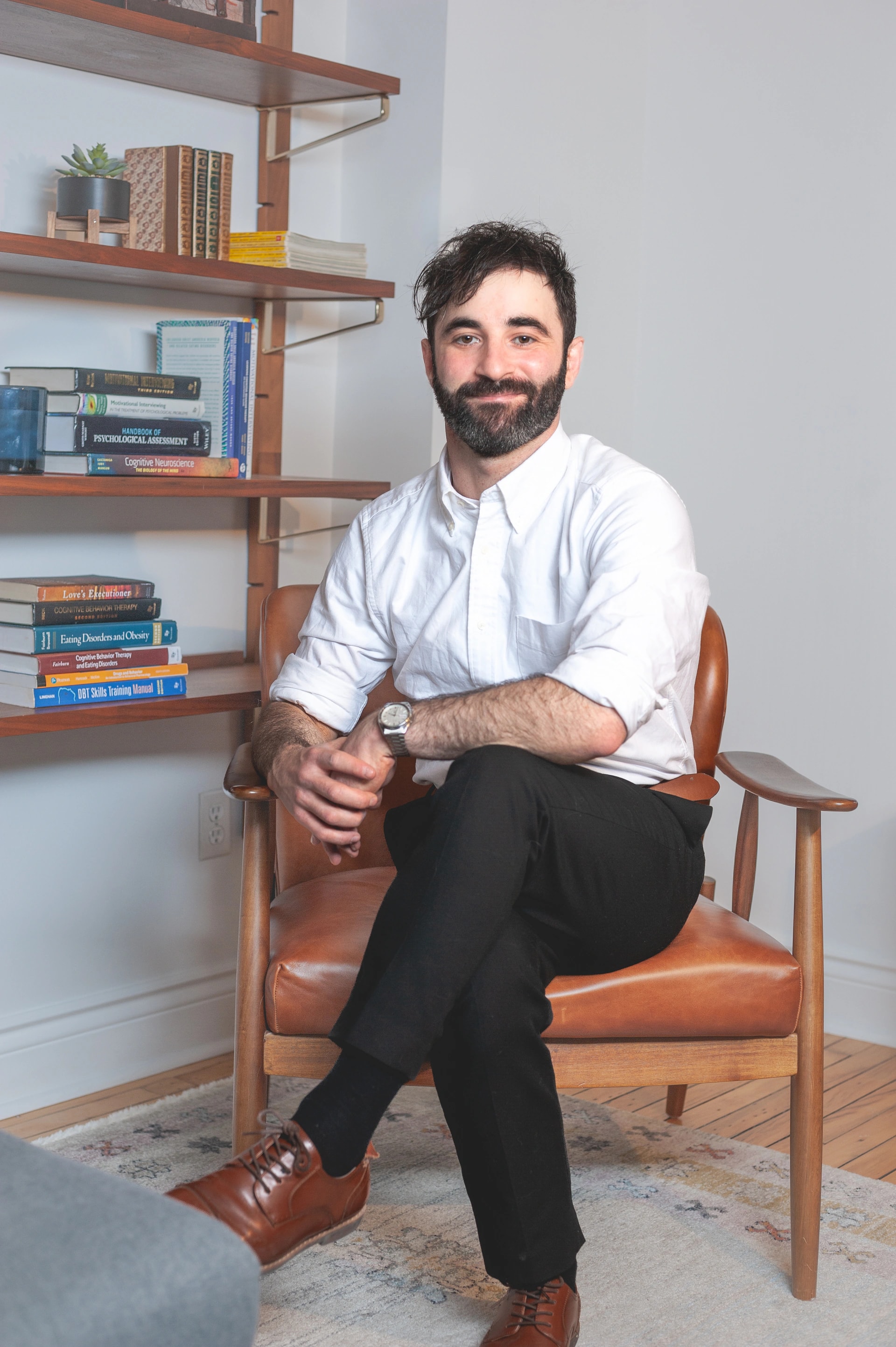 Dr. Joseph Rootman seated beside bookshelves in a clinical office.